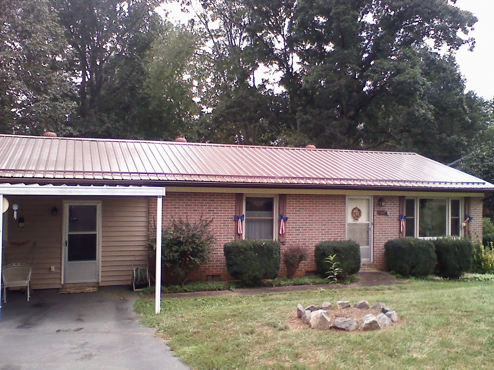 Bronze metal roof and carport on a brick ranch home — Roof Repair work by our crew in Dinwiddie