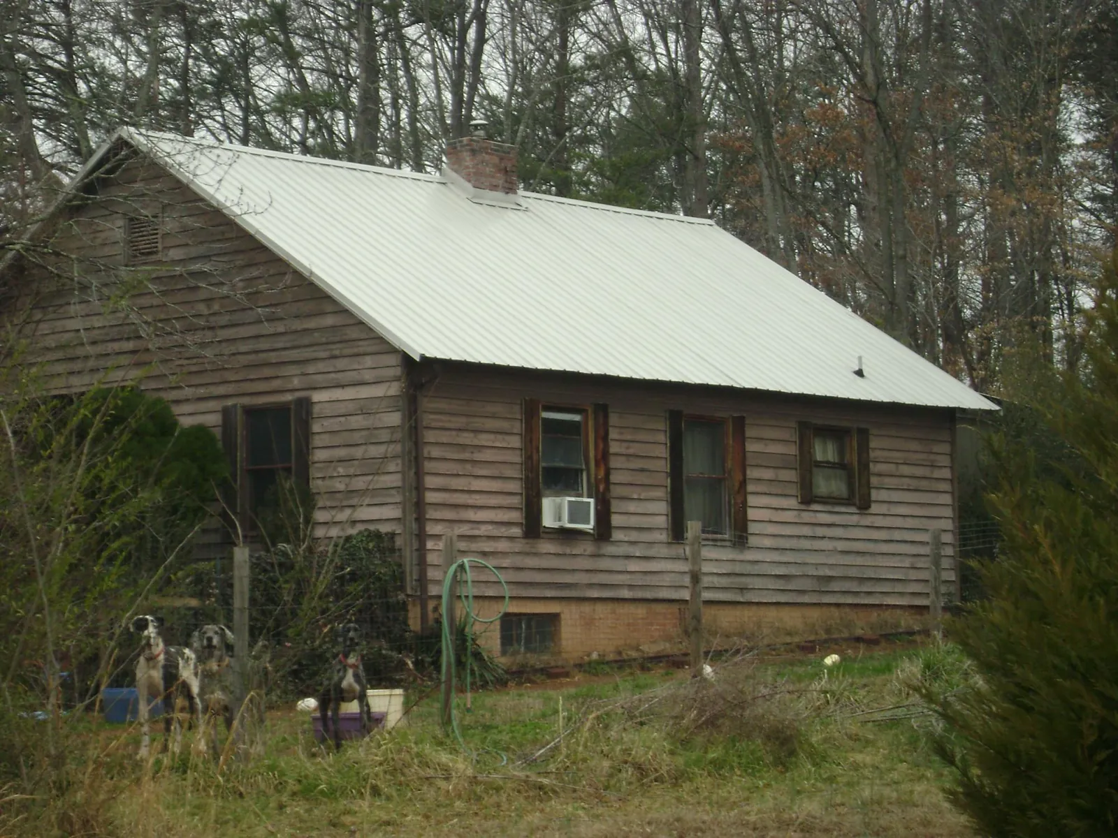 White metal roof on an old wood sided farmhouse, from a Metal Roof Installation job in Dinwiddie